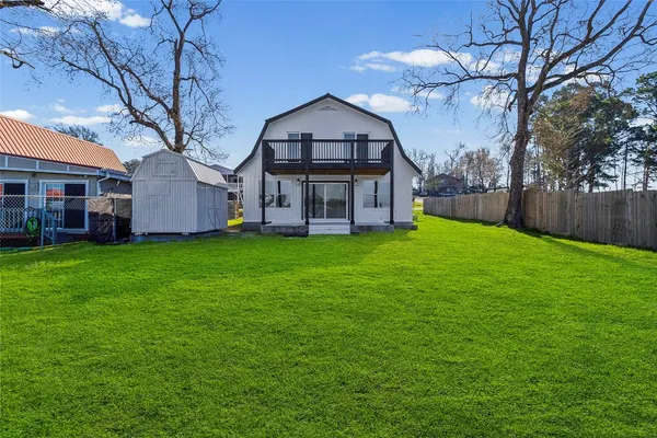 a view of a big house with a big yard and large trees
