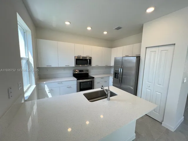 a kitchen with refrigerator and window