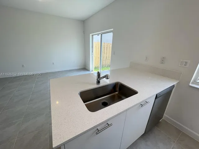 a kitchen that has a sink and a stove in it