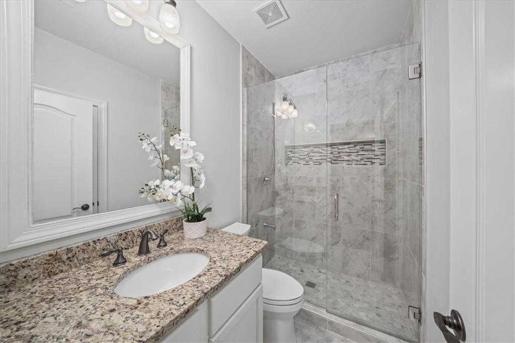 3594 North Druid Hills Road Decatur, GA 30033 - Photo 51 of 57 a bathroom with a granite countertop sink a toilet a mirror and shower