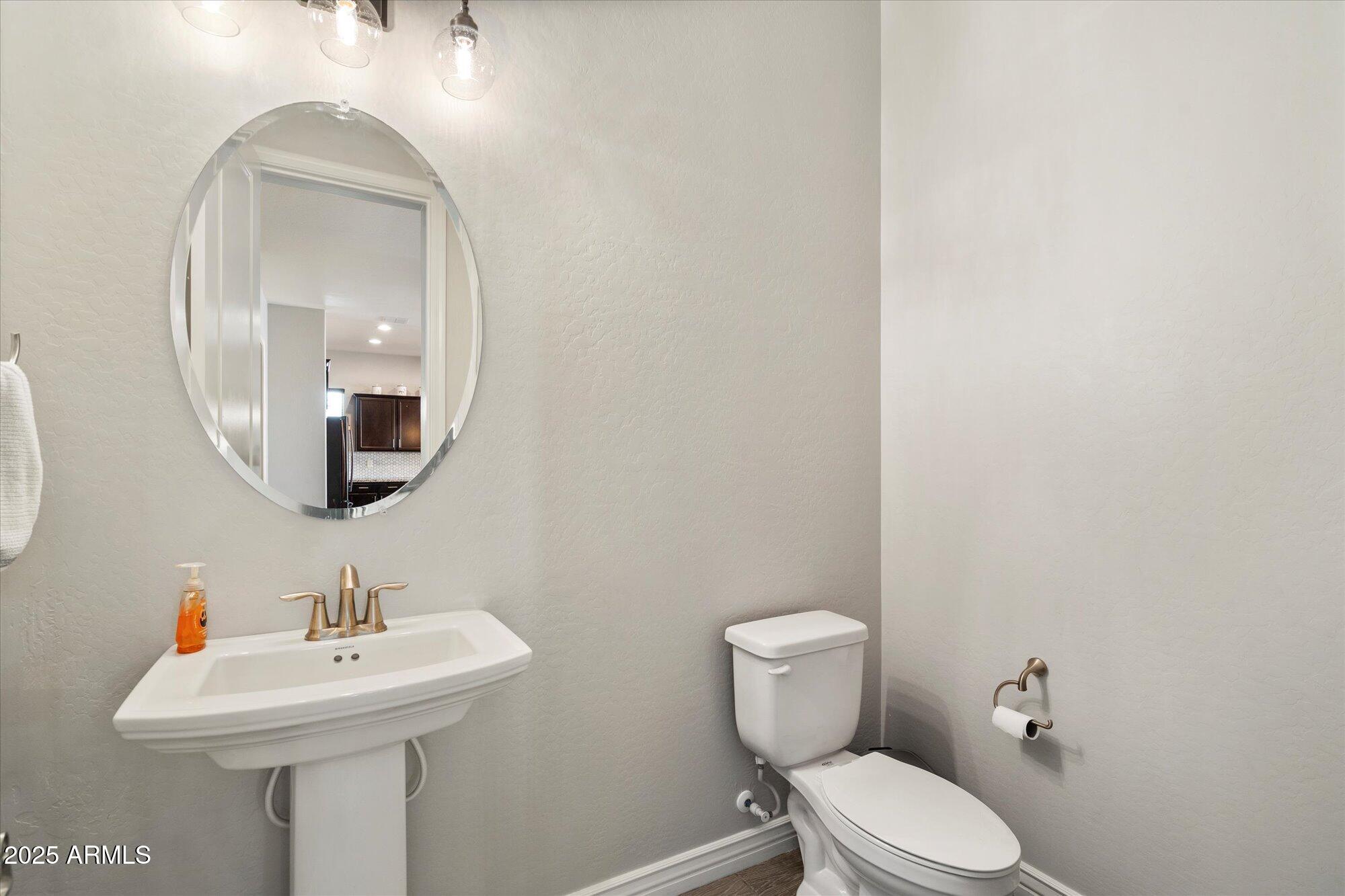 7424 West Jasmine Trail Peoria, AZ 85383 - Photo 23 of 30 a bathroom with a toilet a sink and mirror