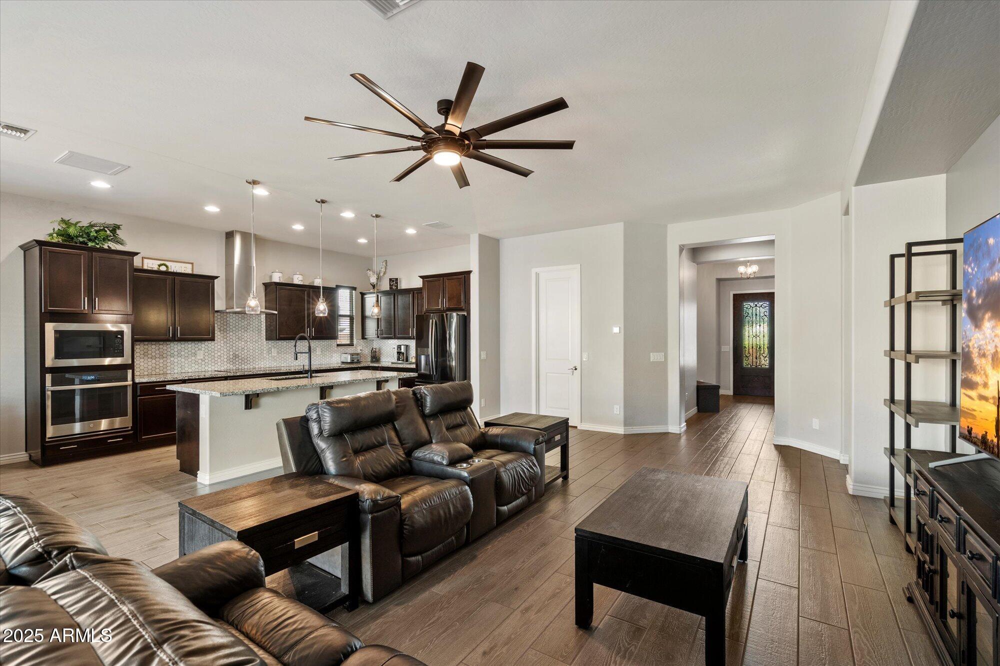7424 West Jasmine Trail Peoria, AZ 85383 - Photo 5 of 30 a living room with stainless steel appliances kitchen island granite countertop furniture and a view of kitchen