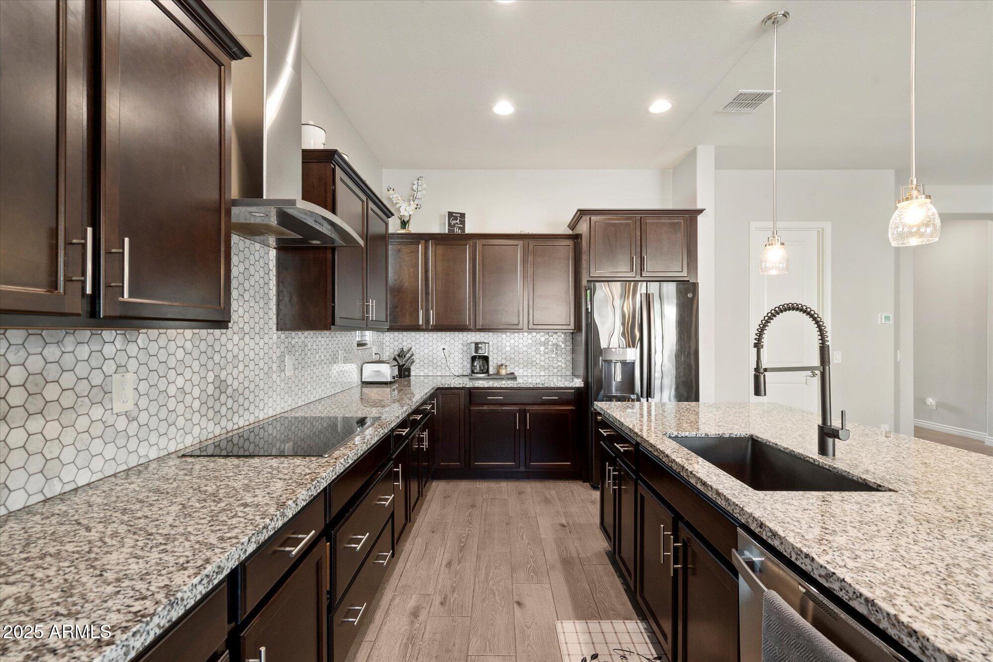 7424 West Jasmine Trail Peoria, AZ 85383 - Photo 6 of 30 a kitchen with stainless steel appliances granite countertop a sink a stove and a wooden floors