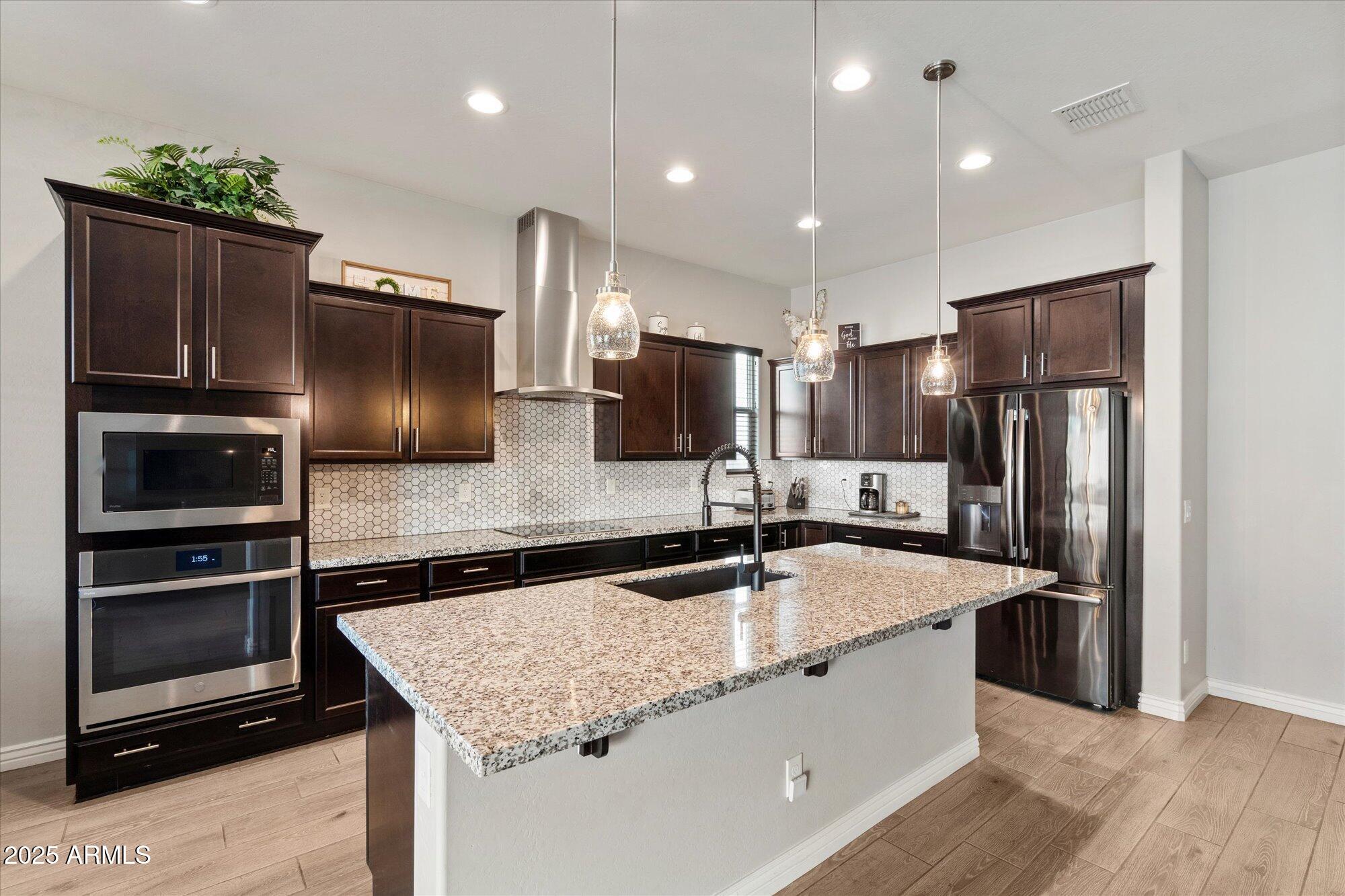 7424 West Jasmine Trail Peoria, AZ 85383 - Photo 7 of 30 a kitchen with stainless steel appliances granite countertop a refrigerator and a sink