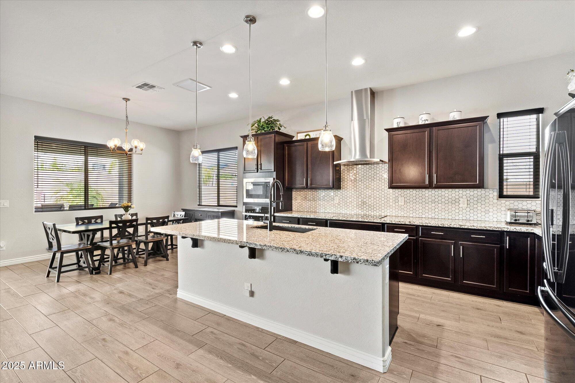 7424 West Jasmine Trail Peoria, AZ 85383 - Photo 10 of 30 a large kitchen with kitchen island a sink counter space and stainless steel appliances
