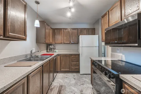 a kitchen that has a sink stainless steel appliances a counter space and cabinets