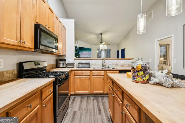 a kitchen with stainless steel appliances a sink stove and cabinets