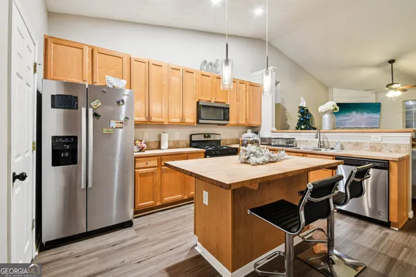 a kitchen with stainless steel appliances a stove a sink refrigerator and a refrigerator
