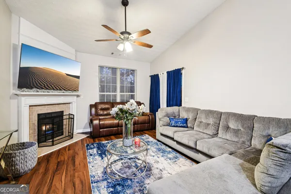 a living room with furniture a fireplace and a flat screen tv