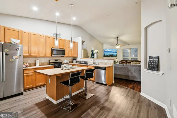 a kitchen with stainless steel appliances a stove a sink a refrigerator and cabinets