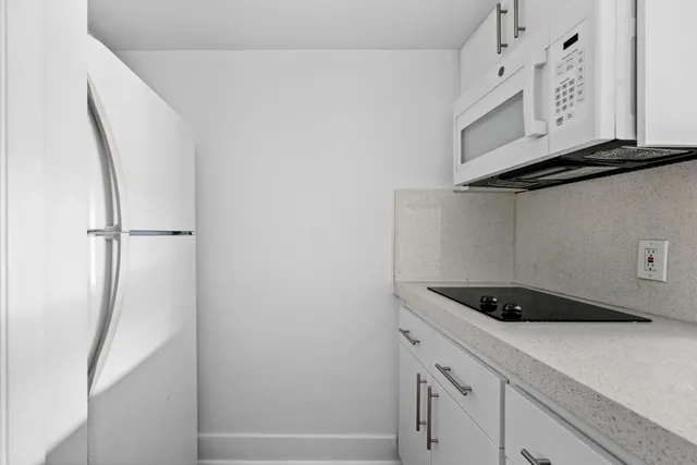 a kitchen with stainless steel appliances kitchen island granite countertop a sink and a refrigerator