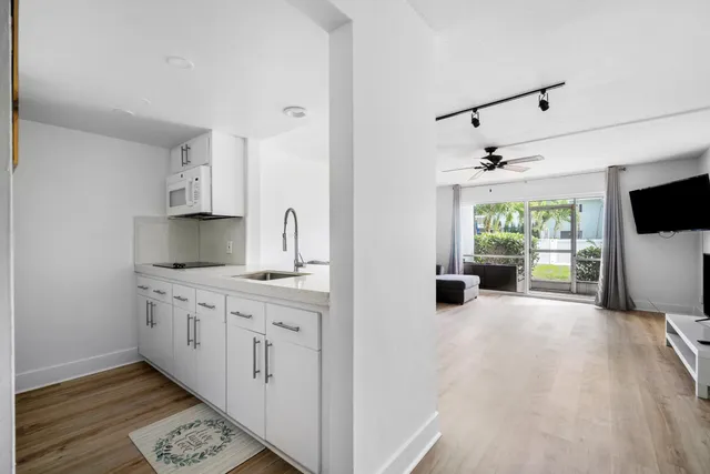 a kitchen with stainless steel appliances granite countertop a sink and a wooden floor