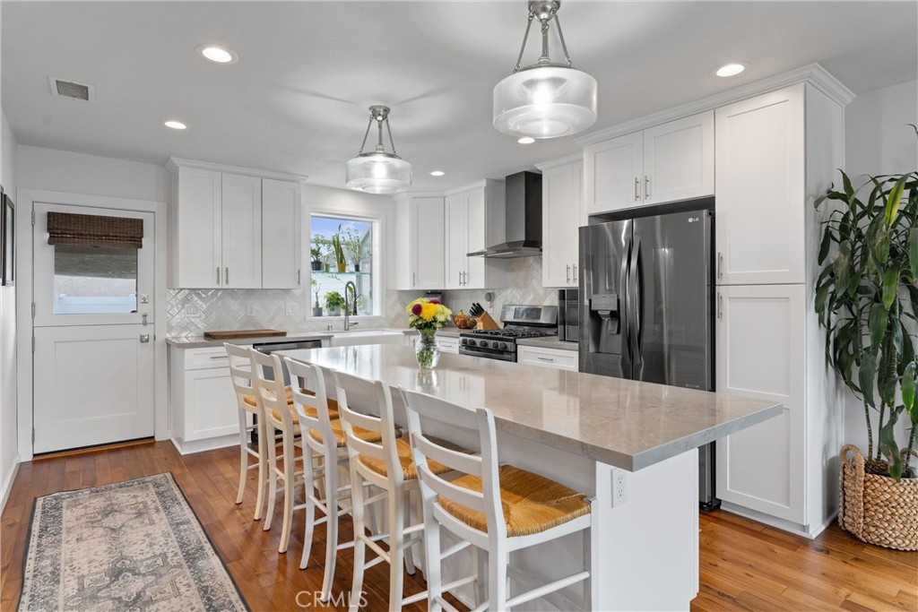 280 Tivoli Drive Long Beach, CA 90803 - Photo 5 of 22 a kitchen with stainless steel appliances a dining table chairs refrigerator and microwave