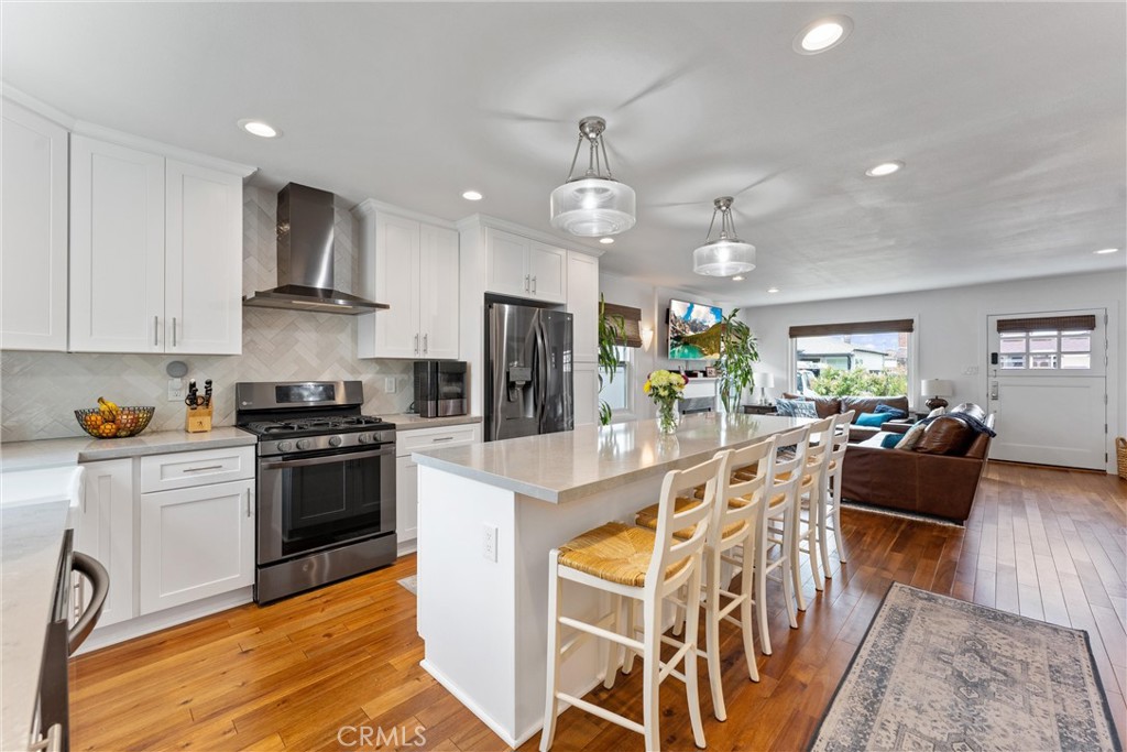 280 Tivoli Drive Long Beach, CA 90803 - Photo 8 of 22 a large kitchen with stainless steel appliances granite countertop a stove refrigerator a dining table and chairs with wooden floor