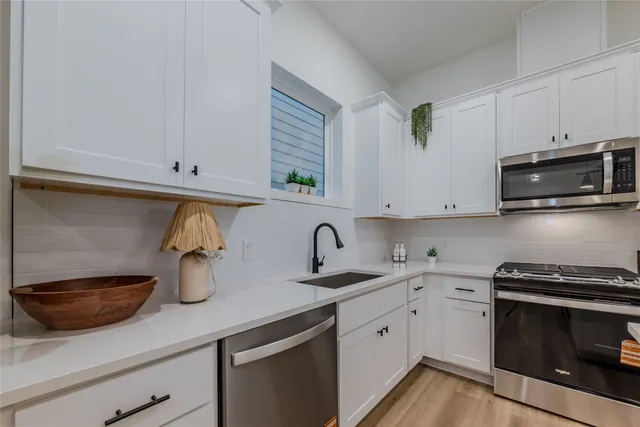 a kitchen with a sink a stove and cabinets