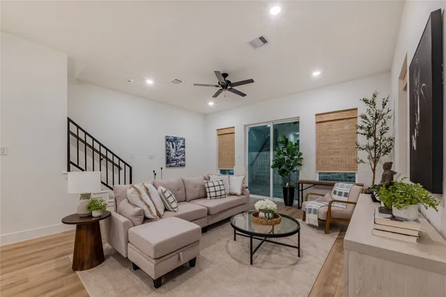 a living room with furniture and a ceiling fan