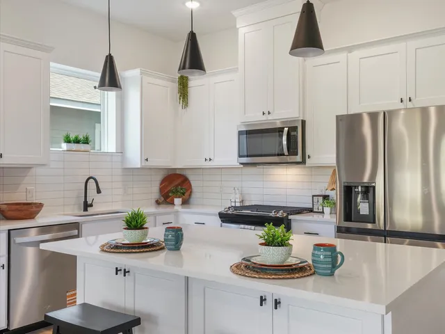 a kitchen with stainless steel appliances a sink a refrigerator a counter space and cabinets