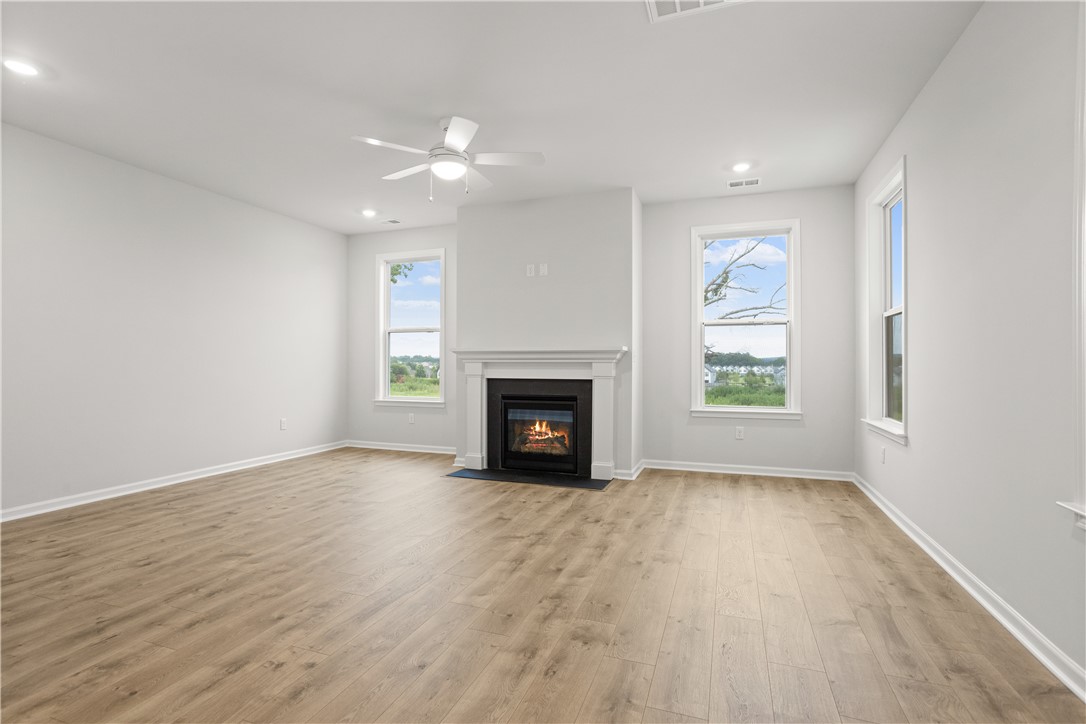 629 Sweetspire Trail, Unit 149 Seneca, SC 29678 - Photo 7 of 30 A comforting fireplace serves as a focal point in this sun-drenched living space with durable plank flooring.