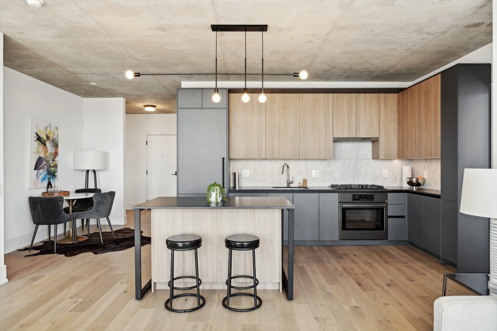 234 West Polk Street, Unit 3503 Chicago, IL 60607 - Photo 11 of 36 a kitchen with granite countertop a stove a refrigerator a dining table and chairs with wooden floor