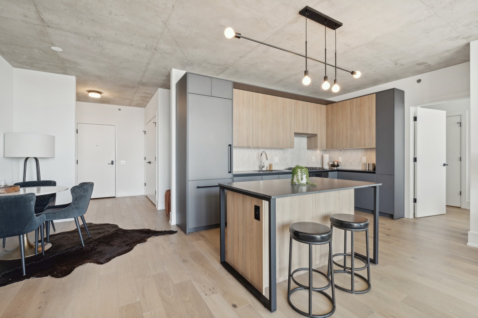 234 West Polk Street, Unit 3503 Chicago, IL 60607 - Photo 12 of 36 a kitchen with kitchen island granite countertop a table chairs refrigerator and cabinets