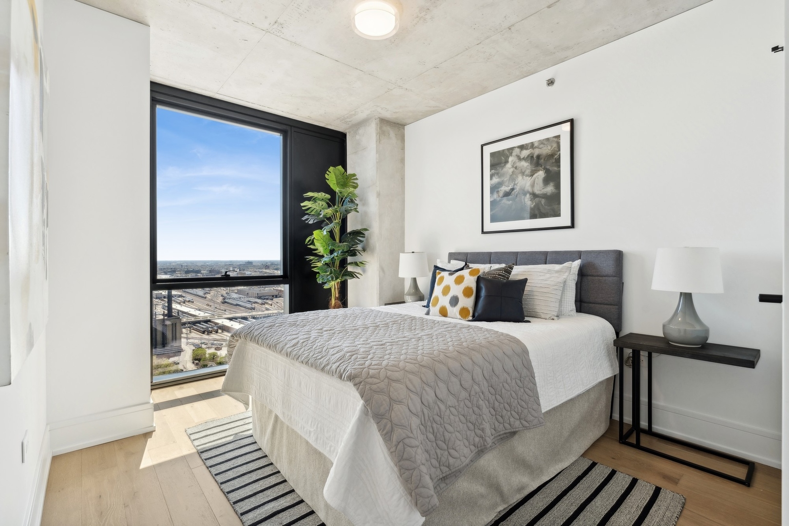 234 West Polk Street, Unit 3503 Chicago, IL 60607 - Photo 16 of 36 a spacious bedroom with bed and painting on the wall