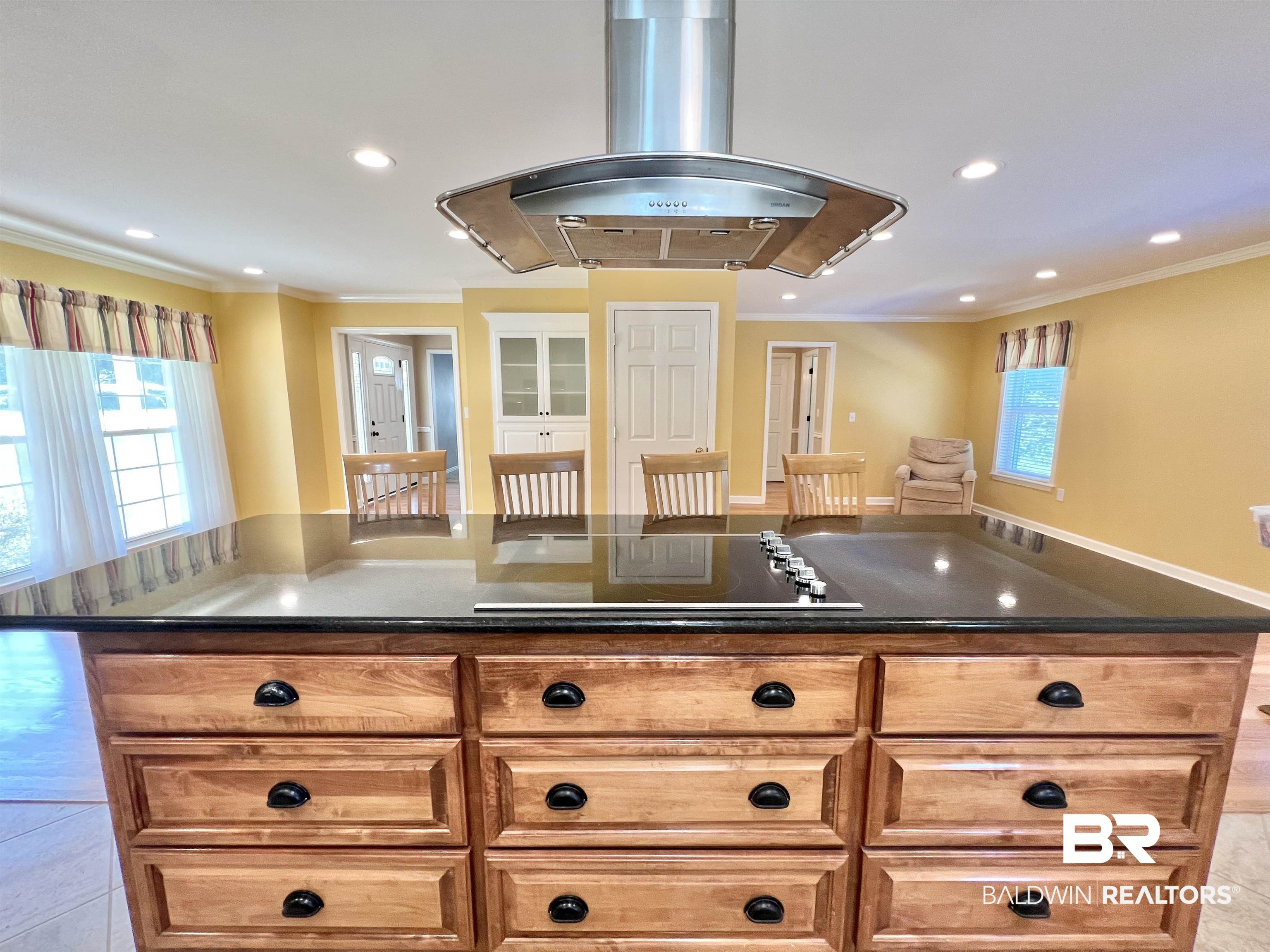 2691 Appleton Road Brewton, AL 36426 - Photo 18 of 60 Kitchen featuring island exhaust hood, a center island, black electric cooktop, ornamental molding, and brown cabinetry