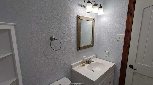 a bathroom with a sink vanity and mirror