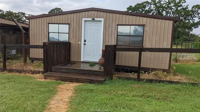 a view of a small house with backyard