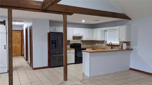 a kitchen with granite countertop a refrigerator and a sink