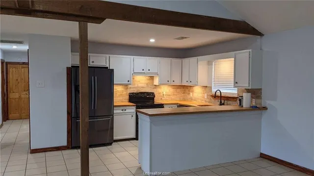 a kitchen with stainless steel appliances granite countertop a refrigerator a sink a stove a microwave and island
