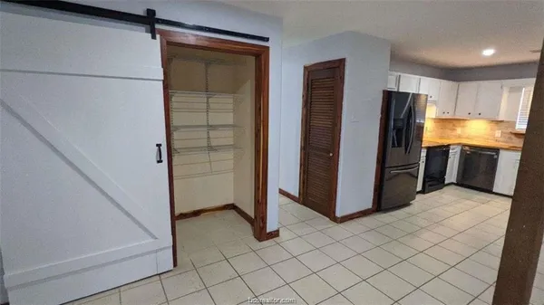 a view of kitchen with refrigerator and cabinets