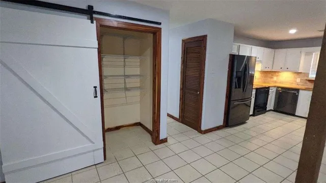 a view of kitchen with refrigerator and cabinets