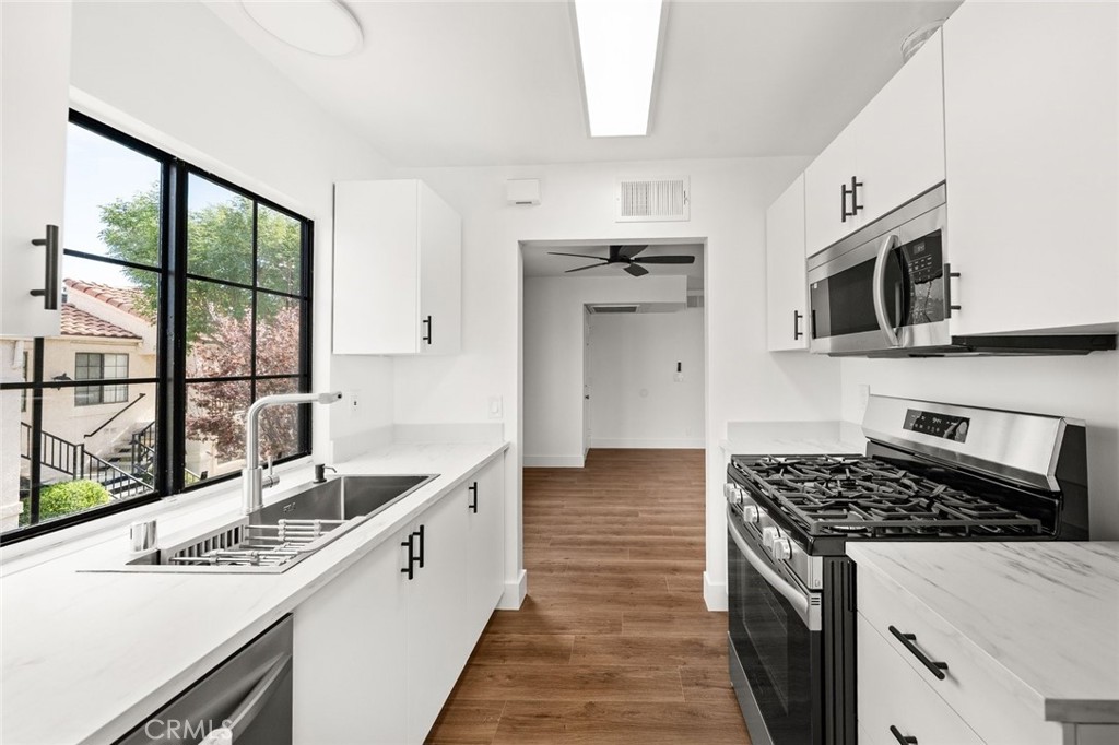 2554 Olive Drive, Unit 84 Palmdale, CA 93550 - Photo 11 of 21 a kitchen with stainless steel appliances granite countertop a sink stove and microwave