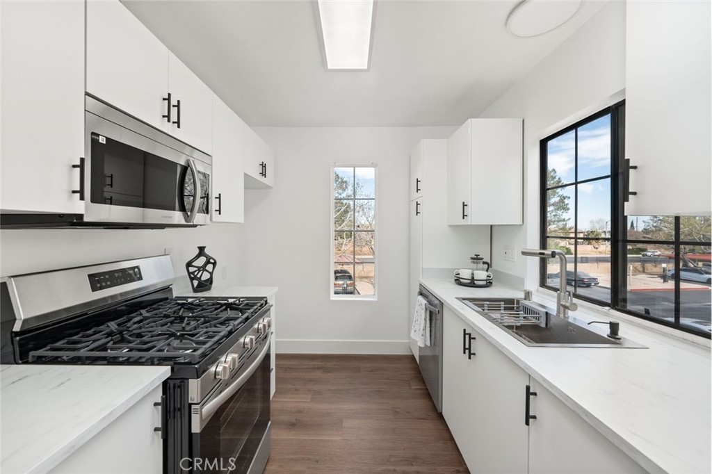 2554 Olive Drive, Unit 84 Palmdale, CA 93550 - Photo 9 of 21 a kitchen with stainless steel appliances a sink stove and microwave