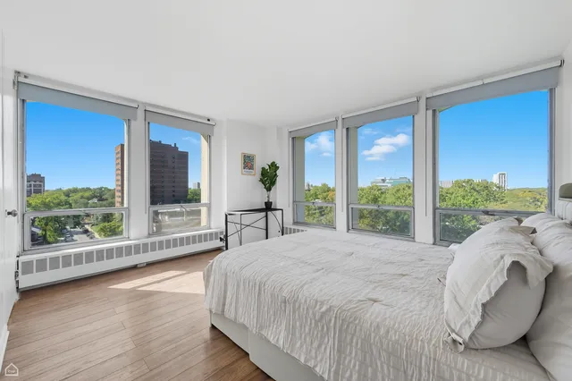 a bed sitting in a spacious bedroom next to a large window