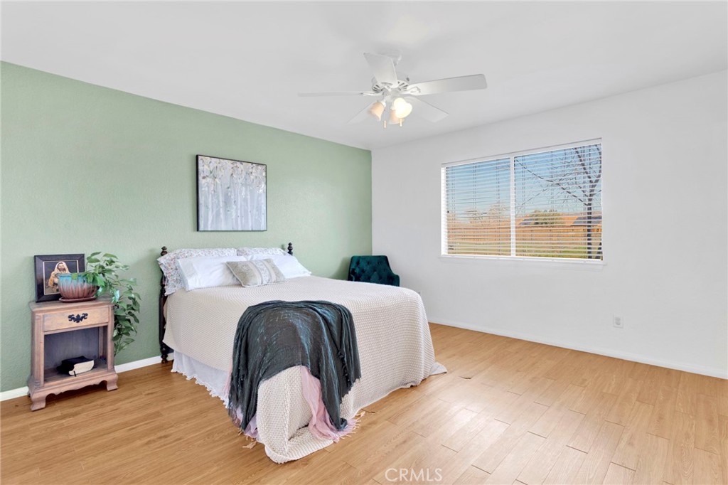 12655 Pocono Road Apple Valley, CA 92308 - Photo 20 of 52 a spacious bedroom with a bed and a chandelier