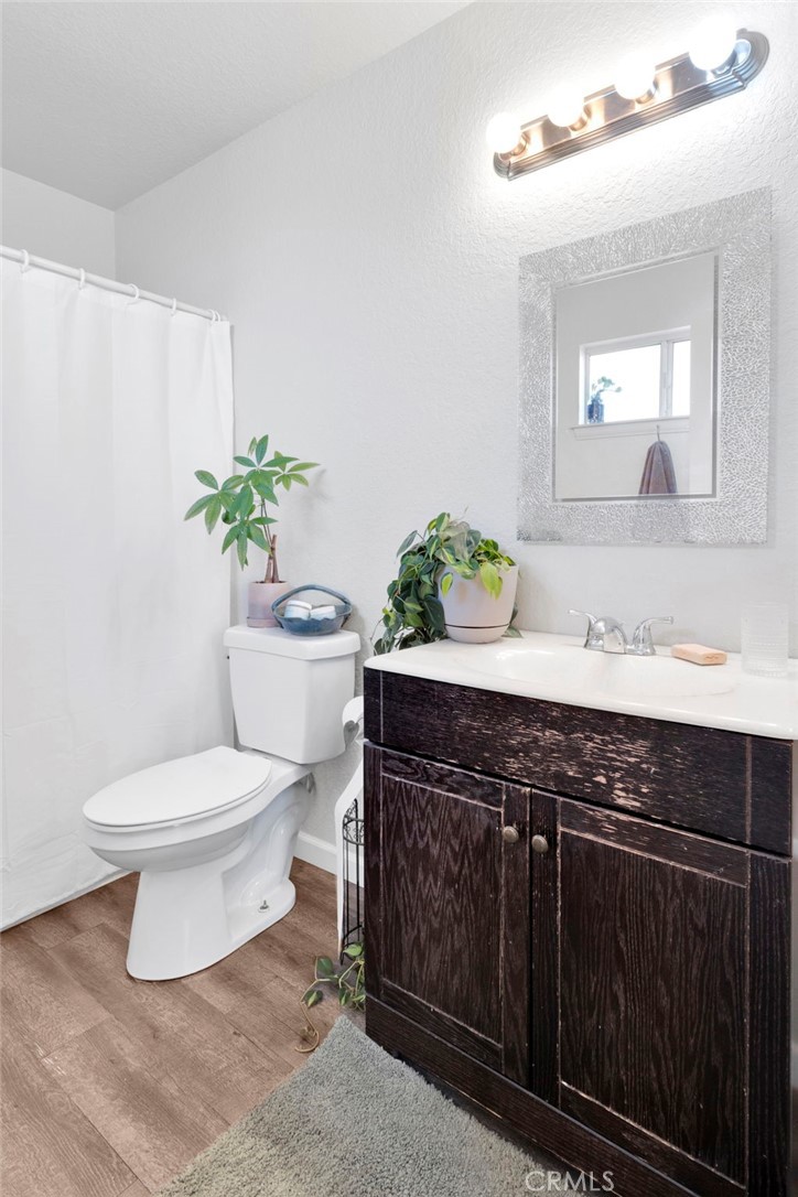 12655 Pocono Road Apple Valley, CA 92308 - Photo 24 of 52 a bathroom with a granite countertop toilet a sink and a mirror