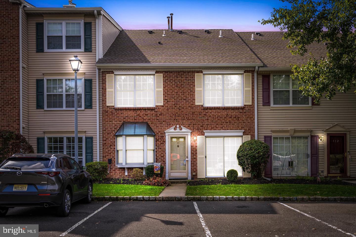 110 Versailles Court Hamilton, NJ 08619 - Photo 1 of 19 a front view of a house with a garden and plants