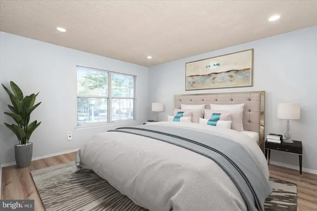 a bedroom with a large bed and a potted plant