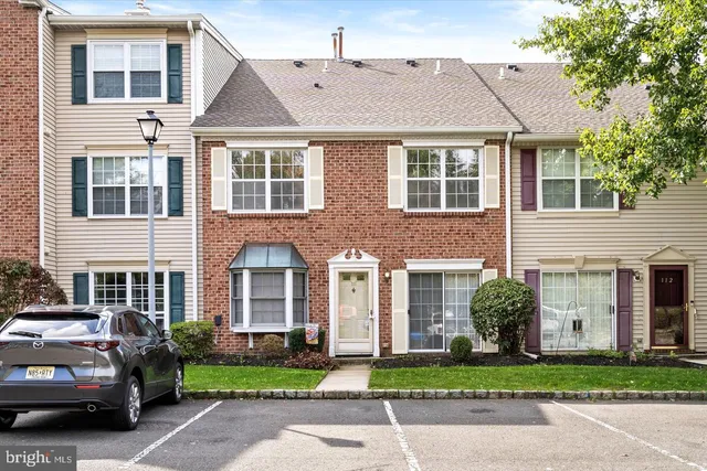a front view of a house with a garden and plants