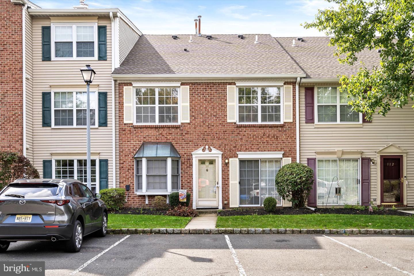 110 Versailles Court Hamilton, NJ 08619 - Photo 2 of 19 a front view of a house with a garden and plants