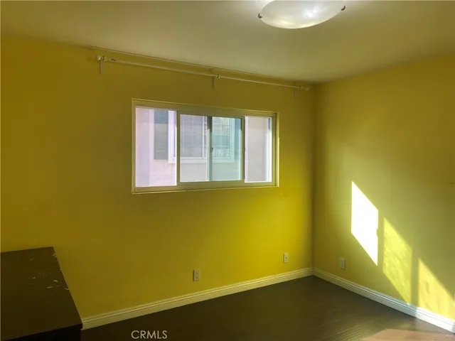 a view of an empty room with closet and a window