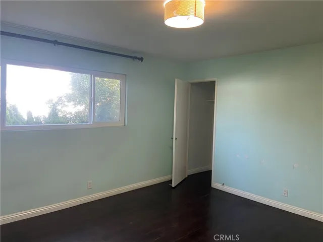 an empty room with wooden floor and closet
