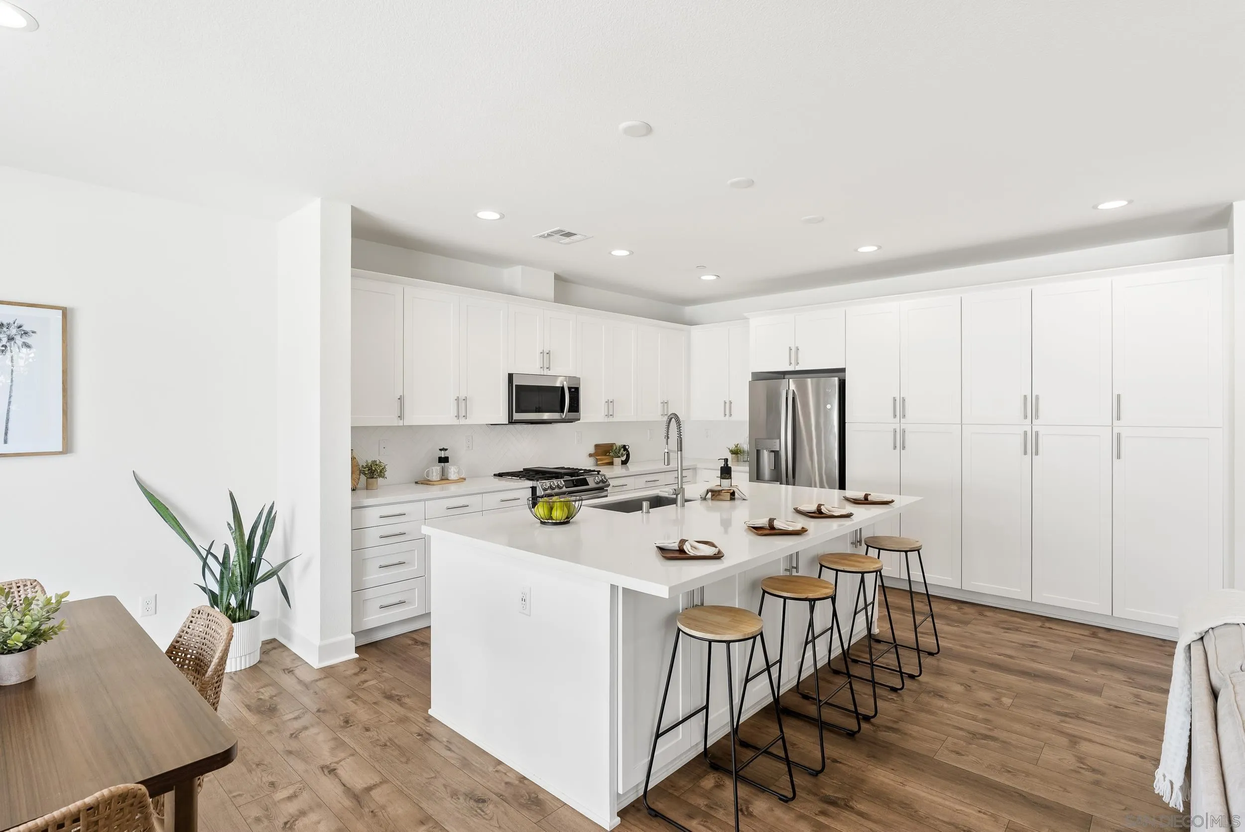 3304 Telaga Road Carlsbad, CA 92010 - Photo 16 of 60 a kitchen with stainless steel appliances a white table chairs and a refrigerator