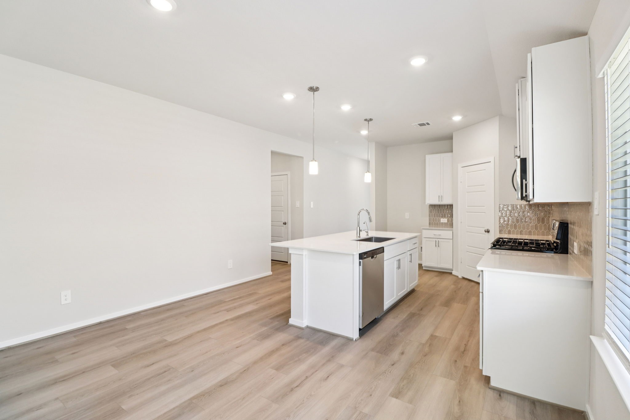 16273 Parish Pointe Court Conroe, TX 77302 - Photo 11 of 29 a kitchen with a sink wooden floor and stainless steel appliances
