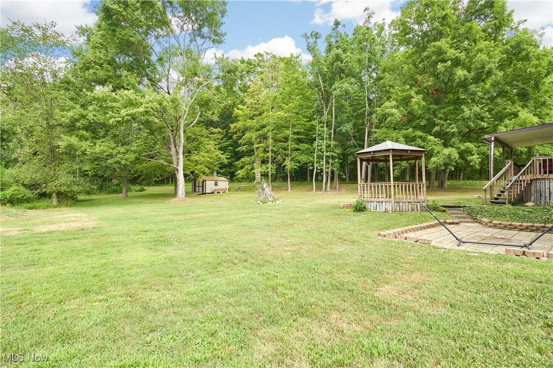 2835 Sunnybrook Road Mogadore, OH 44260 - Photo 23 of 27 View of grassy yard featuring a gazebo, a storage shed, and stairway