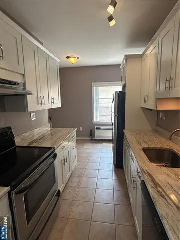 a kitchen with a stove sink and cabinets
