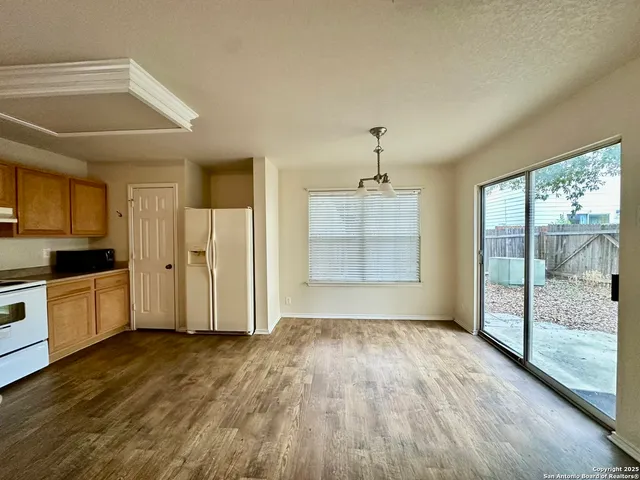 an empty room with a window and a ceiling fan