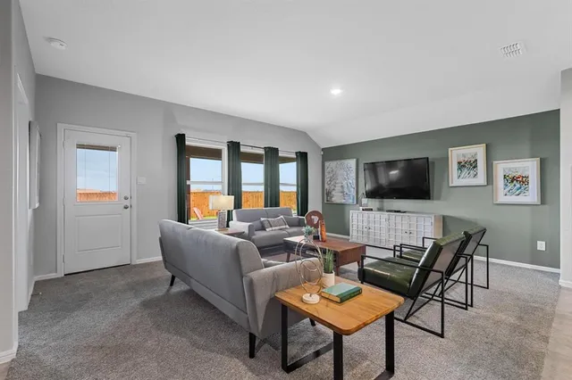 a view of a dining room and livingroom with furniture wooden floor and a rug