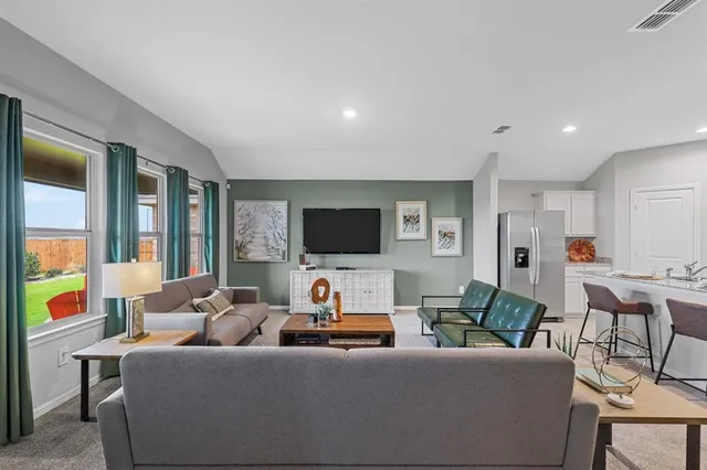 a living room with furniture and kitchen view